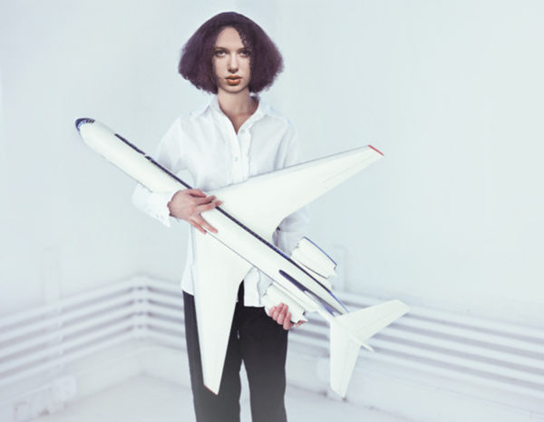 Young Woman Holding Large Model Airplane